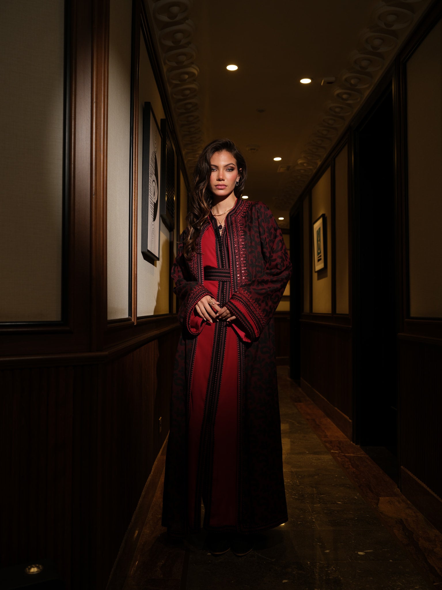 Rouge d’Ombre full-length red and black Moroccan kaftan in corridor view